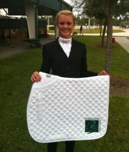 Ashley Walker proudly displays her Everglades Dressage saddlepad, which was presented to her for winning the Young Rider Achievement Award during the GCDA Fall Fling.  (Photo courtesy of JRPR