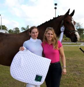 Chloe Hatch (left) and trainer Heidi Degele pose with Hatch’s mount Prince Paradiso and their prize, an embroidered saddlepad from Everglades Dressage. (Photo courtesy of JRPR)